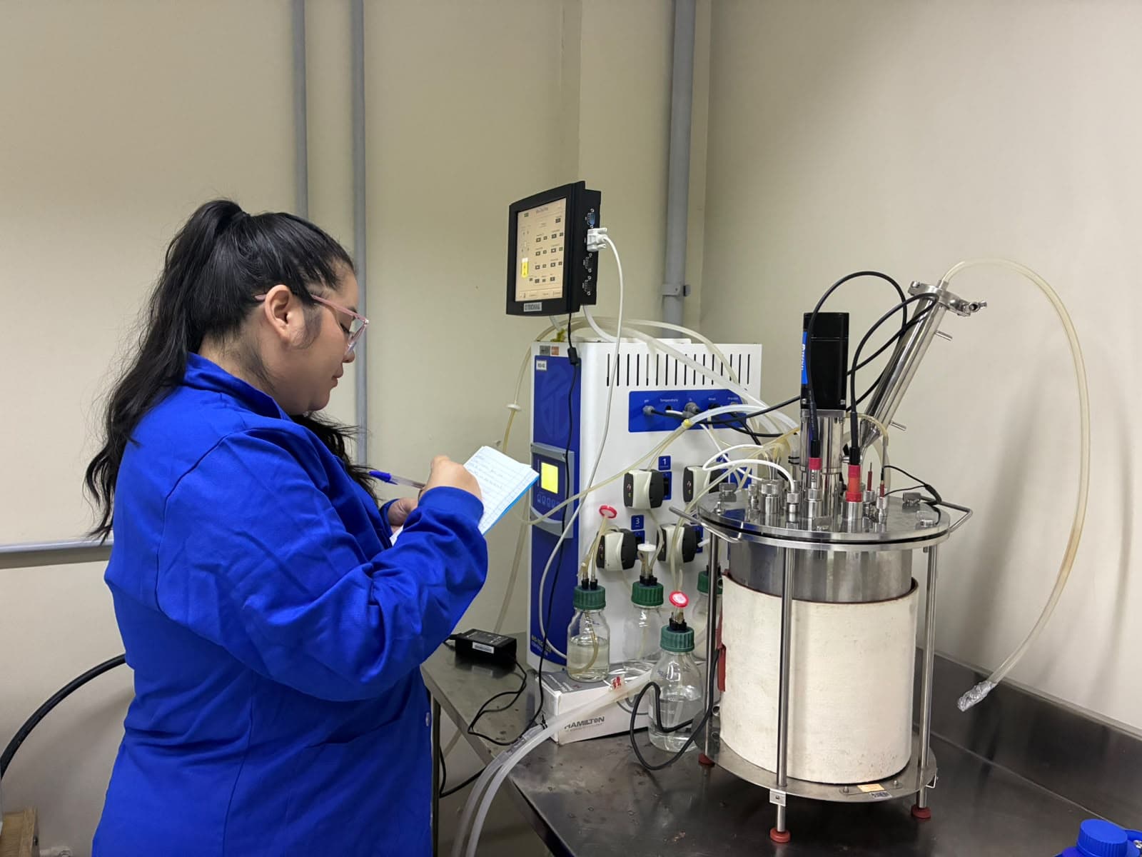 Pesquisadora trabalhando em equipamento de bioprocesso no laboratório da Ecosynth